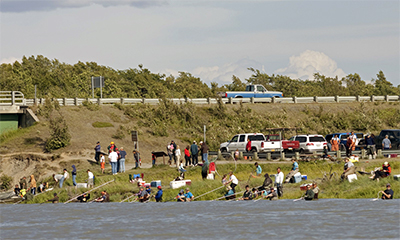 People personal use fishing along a riverbank